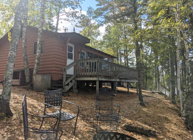 Exterior of Northern Lights, showing a lake facing deck and firepit.