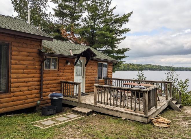Deck area with a picnic table, charcoal grill, and views of the dock.