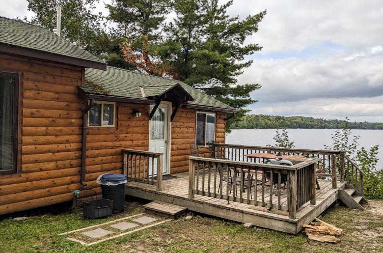 Deck area with a picnic table, charcoal grill, and views of the dock.