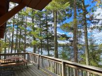 Deck area with a picnic table and charcoal grill.