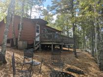 Exterior of Northern Lights, showing a lake facing deck and firepit.