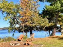 Private yard with shoreline, picnic table, and firepit.