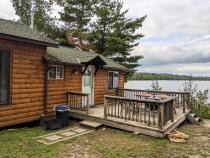 Deck area with a picnic table, charcoal grill, and views of the dock.