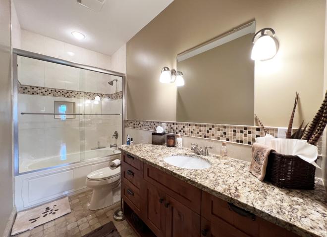 Downstairs bathroom with tub/shower and granite.