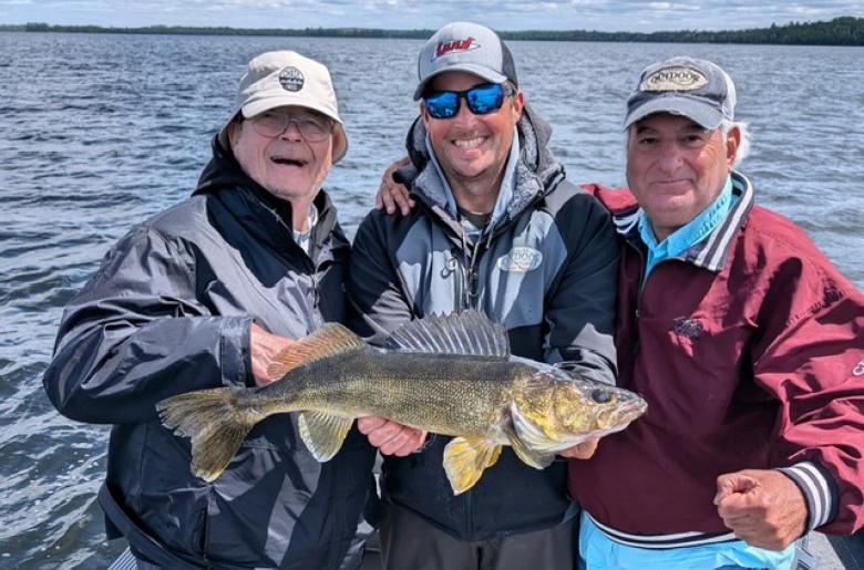 Jason Freed and clients holding a nice Walleye