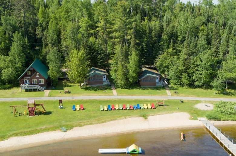 Photo of the Pehrson Lodge beach with cabins and a nice swimming area.